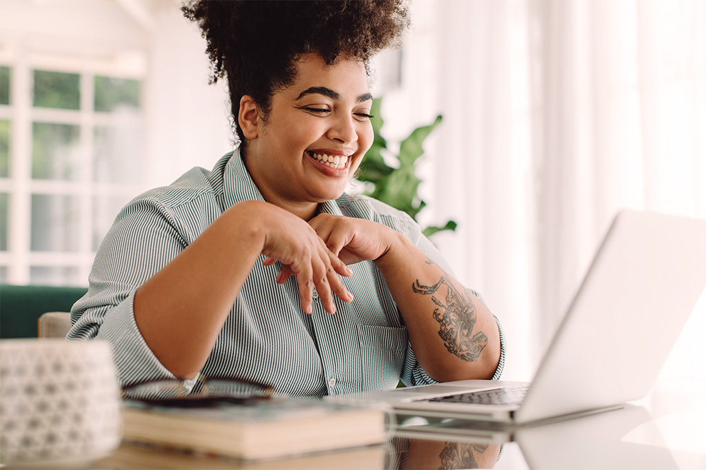 woman smiling looking at laptop screen